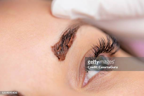 close-up photo of woman's eyebrow with dye applied on it - stock photo - dye imagens e fotografias de stock
