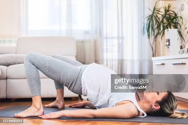 schwangere mutter übt yoga zu hause - pregnant yoga stock-fotos und bilder