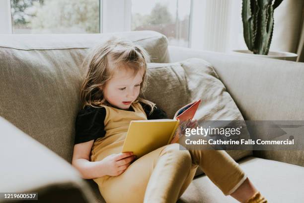 little girl reading - sfogliare libro foto e immagini stock