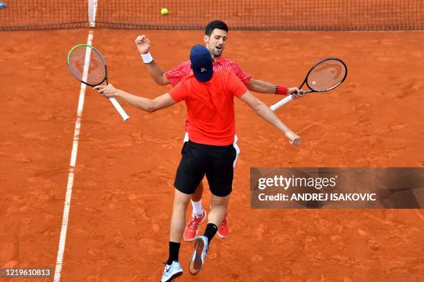 Serbian tennis players Novak Djokovic and Filip Krajinovic do a chest bump during an exhibition double match at a charity exhibition hosted by Novak...
