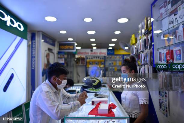 Shop staff selling mobile phone as Nepal government loosen lockdown during ongoing nationwide lockdown as concerns about the spread of Corona Virus...