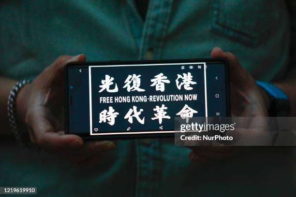 Demonstrator holds a mobile phone reading &quot;Free Hong Kong, Revolution Now&quot; during a protest in Seoul, South Korea on June 12, 2020. Dozens...