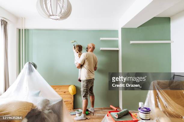 lavoro di squadra nella ristrutturazione della casa - papà e figlia dipingendo insieme - house shifting foto e immagini stock