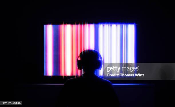 person in front of tv screen with headphones - saturated color 個照片及圖片檔