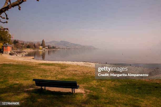 empty bench next to the lake in lausanne during covid-19 quarantine - lake geneva switzerland stock pictures, royalty-free photos & images