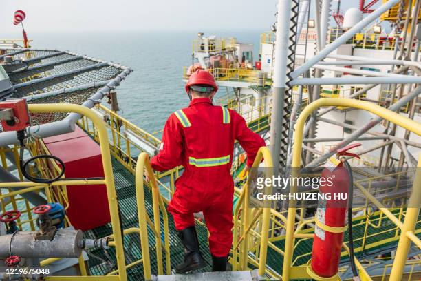 young oil worker on offshore oil rig - plataforma de perfuração - fotografias e filmes do acervo