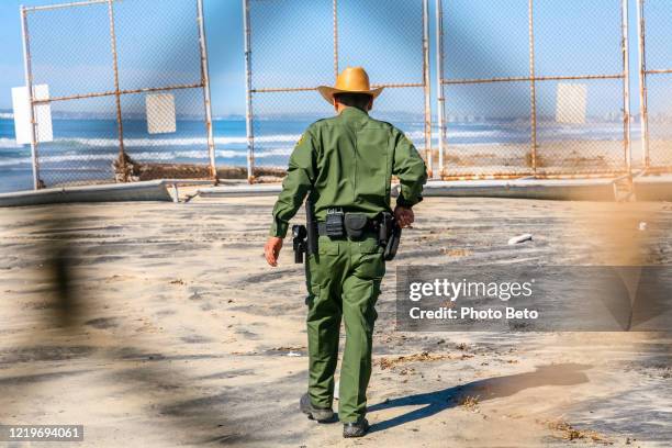 un oficial fronterizo de ee.uu. inspecciona el muro en la frontera entre estados unidos y méxico - patrulla de frontera de los estados unidos fotografías e imágenes de stock