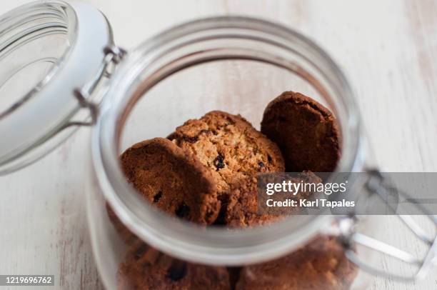 still life of freshly baked cookies on a glass jar - cookie jar stock-fotos und bilder