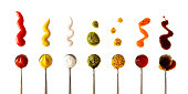 Ketchup, mustard, mayonnaise, basil pesto, sweet chili sauce and teriyaki soy sauce in spoon isolated on white background, top view. Various seasoning and dip border horizontal banner format