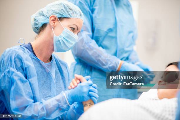 cirujanos en un hospital - giving birth fotografías e imágenes de stock