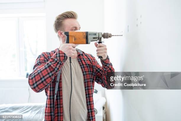 young man doing home improvements. - drill stockfoto's en -beelden