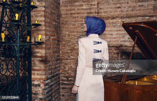 vista trasera de joven musulmana de pie cerca del frente del piano de la pared - arabic keyboard fotografías e imágenes de stock