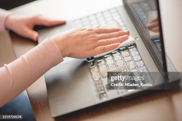 woman wiping down dust from her laptop - dirty wet wipe stock pictures, royalty-free photos & images