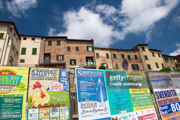 advertising posts in front of historic houses in lucignano - lucignano d'asso stock pictures, royalty-free photos & images