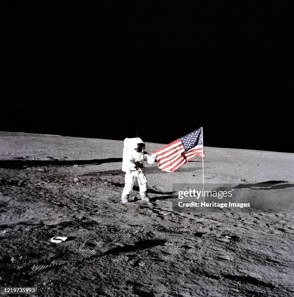 Apollo 12 During the first extravehicular activity, astronaut Charles Conrad, Jr., Apollo 12 commander, releases the United States flag on the lunar...