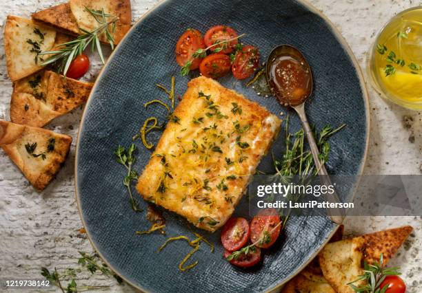 gepaneerde, pangebakken fetakaas (saganaki) met gepeperde honing en gebakken pitachips - feta stockfoto's en -beelden