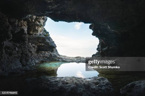 a small grotto with a reflecting pool - grotte stock-fotos und bilder