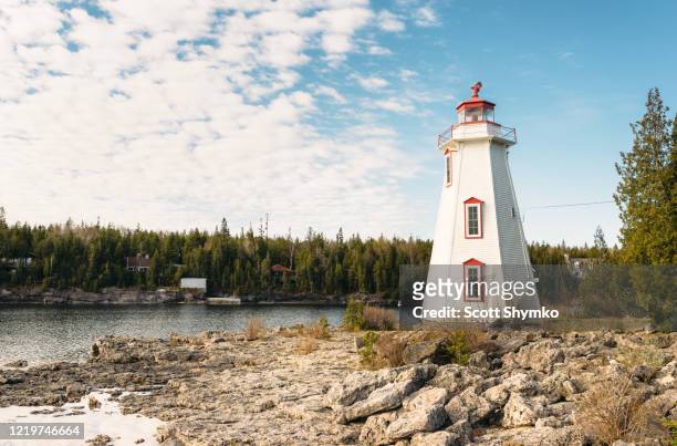 lighthouse overlooking big tub harbour, tobermory, ontario - ontario canada stock pictures, royalty-free photos & images