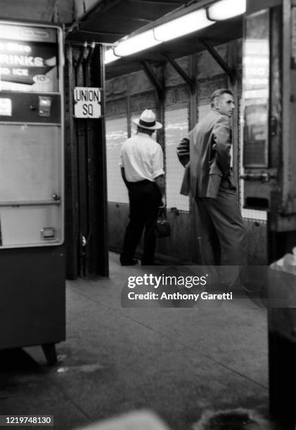 View of two men waiting for the train at the Union Square subway stoop in New York City, New York circa 1965