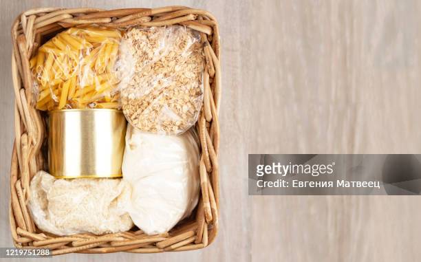 donation food delivery help basket box cereals, pasta, canned on white natural wooden background. - storage basket stock pictures, royalty-free photos & images