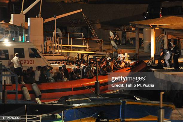 An Italian coastguard boat carrying migrants of an undetermined nationality docks in the island port on August 24, 2011 in Lampedusa, Italy. Over...