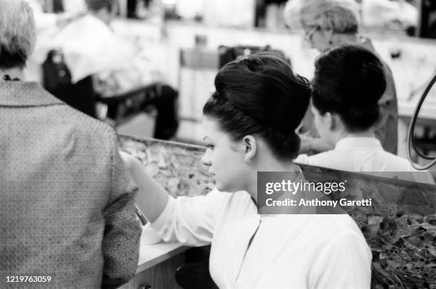 View of a woman with a beehive hairdo inside Joseph's Barber Shop in Brooklyn, New York circa 1965