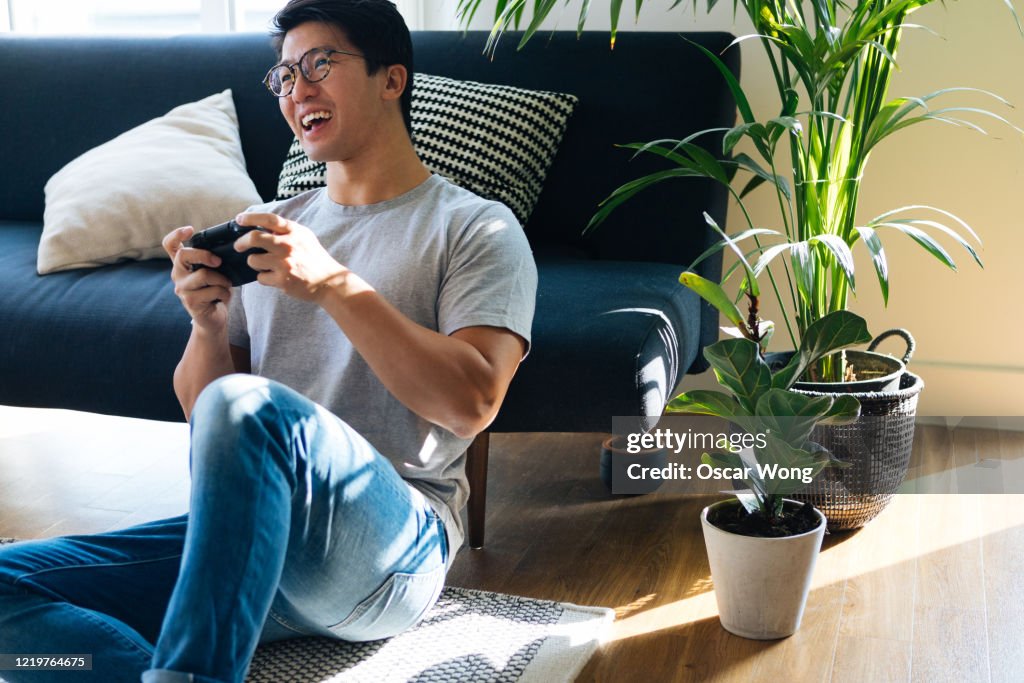 Young Man Playing Video Game At Home
