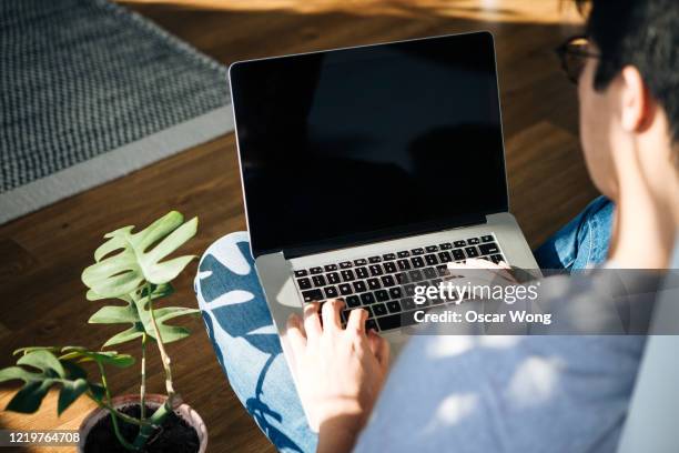 young man using laptop at home - laptop screen stock-fotos und bilder