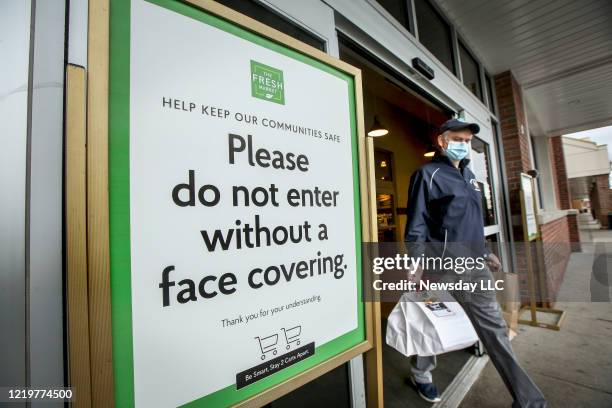 Sign outside the Fresh Market supermarket in Smithtown, New York asks customers not to enter without a face covering due to coronavirus concerns on...