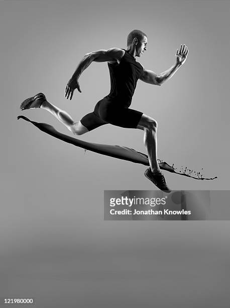 male athlete running above liquid splash - forward athlete stockfoto's en -beelden