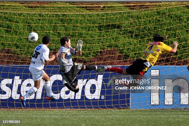 Marvin Ceballos of Comunicaciones heads the ball past goalkeeper Daniel Cambronero to score against Herediano during their Concacaf Championship...