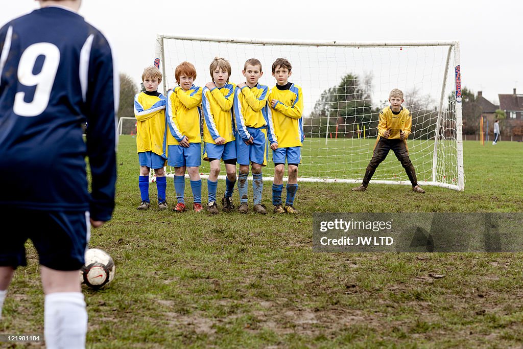 Boy taking free kick during football game