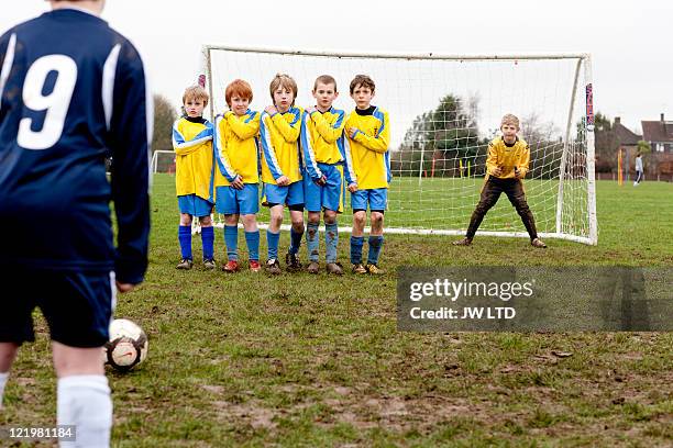 boy taking free kick during football game - kids' soccer stock pictures, royalty-free photos & images