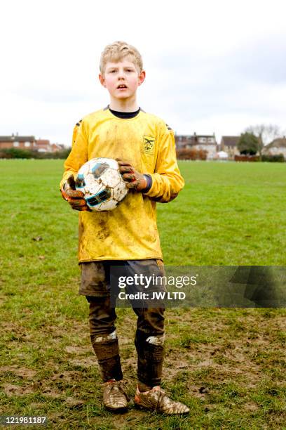 boy wearing football strip holding football, portrait - boys football stock pictures, royalty-free photos & images