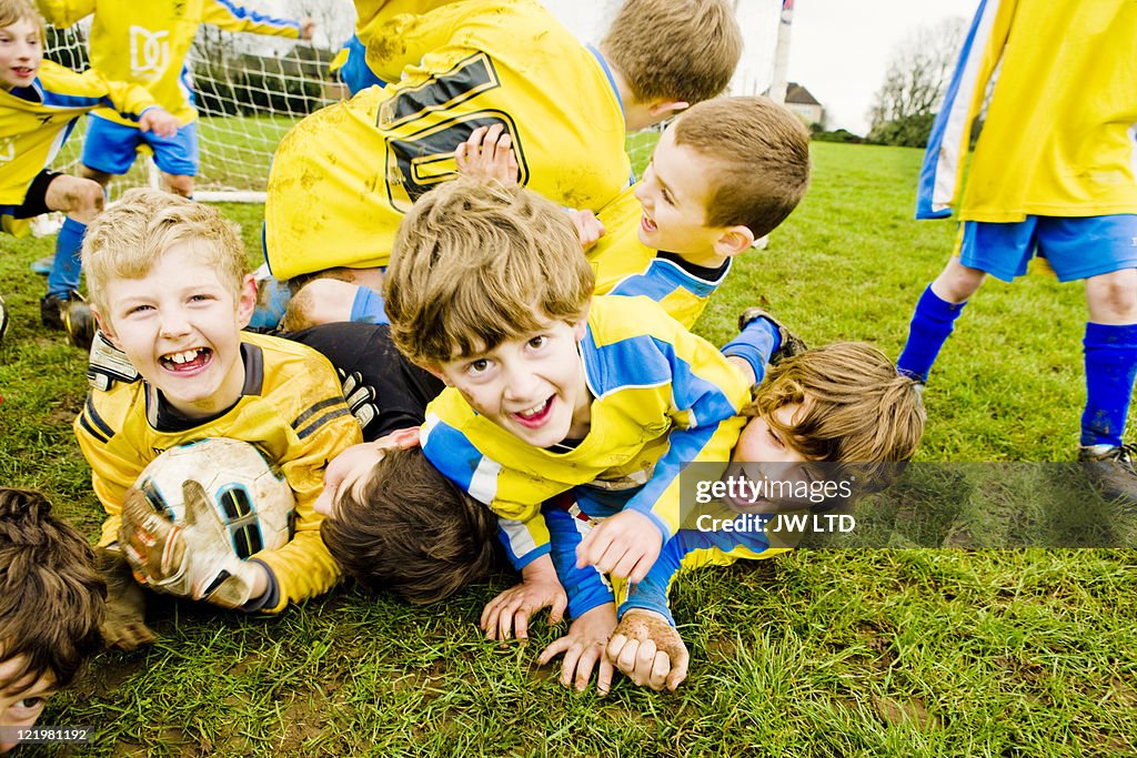 Boys lying on grass with football