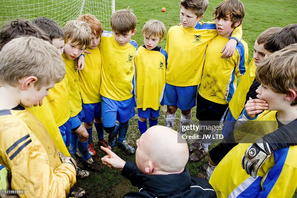 Boys with football coach, high angle