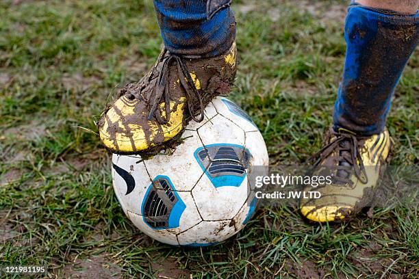 close up of muddy football boot on football - soccer boot stock pictures, royalty-free photos & images