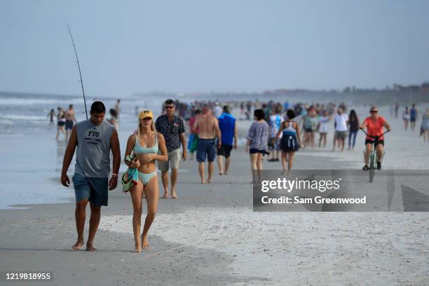 People walk down the beach on April 19, 2020 in Jacksonville Beach, Florida. Jacksonville Mayor Lenny Curry announced Thursday that Duval County's...