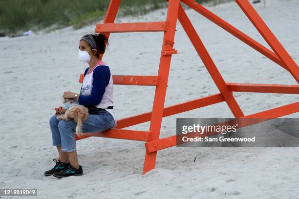 Person sits on a lifeguard chair on April 19, 2020 in Jacksonville Beach, Florida. Jacksonville Mayor Lenny Curry announced Thursday that Duval...