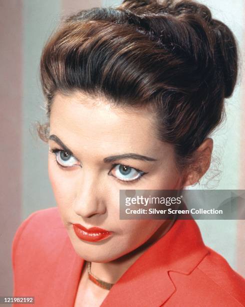 Yvonne De Carlo , Canadian actress, wearing a red jacket and a gold necklace, circa 1955.