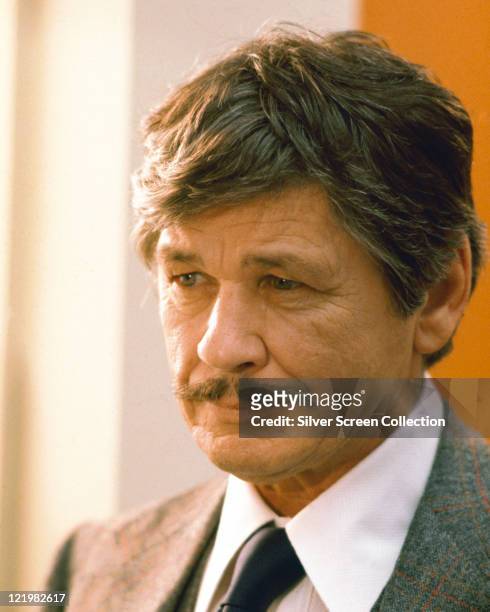 Charles Bronson , US actor, wearing a tweed jacket, a white shirt and a black tie, circa 1975.
