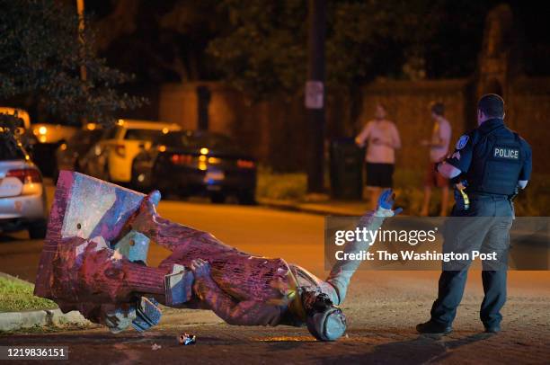 Richmond police officer stand by the statue of Confederate President Jefferson Davis after it was pulled down off of it's pedestal on Monument Avenue...