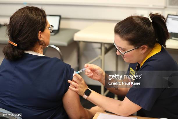 Registered nurse Heather Hoppe receives a flu vaccination in the trial clinic at Sir Charles Gairdner hospital on April 20, 2020 in Perth, Australia....