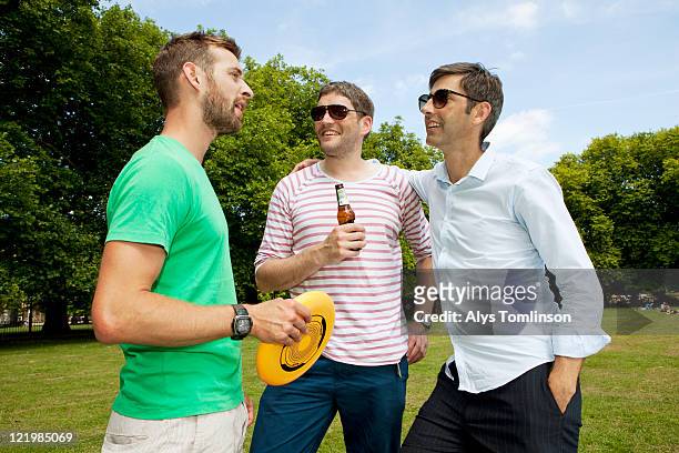 friends relaxing in a city park - only mid adult men stock pictures, royalty-free photos & images
