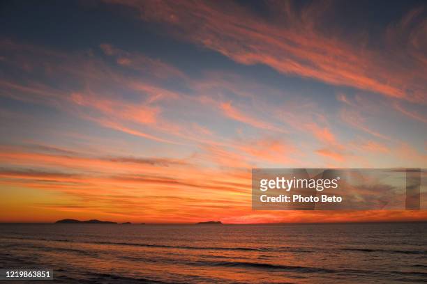 un tramonto nuvoloso e colorato sulla costa pacifica del messico - tramonto foto e immagini stock