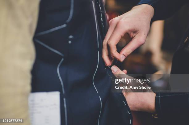 fingers pinning a tailored suit - tailor stockfoto's en -beelden