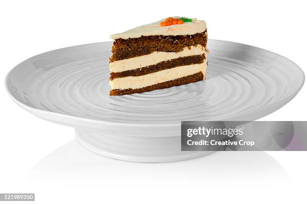 slice of carrott cake sat on a porcelain cake stan - carrot cake isolated stock pictures, royalty-free photos & images
