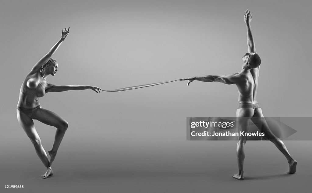 Female and male dancers connected through liquid