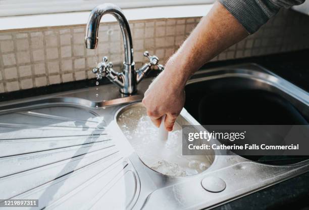 plunging a sink - plugging in stockfoto's en -beelden