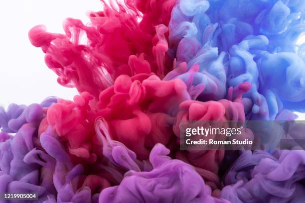 colorful ink swirling in water. - colour image stock pictures, royalty-free photos & images